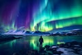 The mountaineer looks admiringly at the northern lights or Aurora phenomenon.