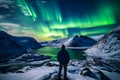 The mountaineer looks admiringly at the northern lights or Aurora phenomenon.