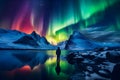 The mountaineer looks admiringly at the northern lights or Aurora phenomenon.