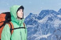The mountaineer looks at the peak, standing against a winter mountain landscape. Royalty Free Stock Photo