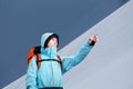 The mountaineer pointing on mountain slope, standing against a winter mountain landscape. Royalty Free Stock Photo