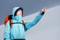 The mountaineer pointing on mountain slope, standing against a winter mountain landscape. Royalty Free Stock Photo