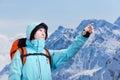 The mountaineer pointing at peak, standing against a winter mountain landscape. Royalty Free Stock Photo