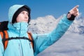 The mountaineer pointing at peak, standing against a winter mountain landscape. Royalty Free Stock Photo