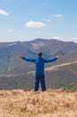 Mountaineer reaches the top of a mountain in sunny