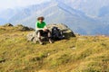 Mountaineer resting on rock in front of mountain panorama in Hohe Tauern Alps