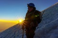 mountaineer silhouette at sunrise with ice ax in hand