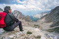 Mountaineer sitting on the rock admiring the mountain panorama