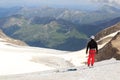 Mountaineer standing on glacier and looking towards Grossglockner High Alpine Road and mountain panorama in Austria