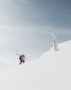 Mountaineer walking up along a snowy mountain with the skis in the backpack. Skier on the climbing track for freeride-descent.