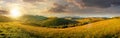 mountainous countryside landscape at sunset. panorama of a grassy rural field on the hill in evening light Royalty Free Stock Photo