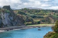 Mountainous green landscape by the sea with promenade in the Asturian city of Luarca, Spain. Royalty Free Stock Photo