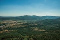 Mountainous landscape covered by trees and cultivated fields Royalty Free Stock Photo