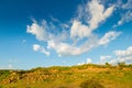 Mountains of Armenia, covered with greenery and stones, clouds on a blue sky