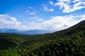 Mountains with Christmas trees against the blue sky with clouds. Beautiful panoramic view of firs and larches coniferous forest Royalty Free Stock Photo