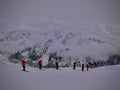 Mountains in clouds with skiers Royalty Free Stock Photo