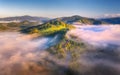 Mountains in clouds at sunrise in summer. Aerial view