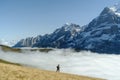 Tourist stands in front of the mountains and clouds in the valley at Grindewald, Switzerland Royalty Free Stock Photo