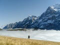 Tourist stands in front of the mountains and clouds in the valley at Grindewald, Switzerland Royalty Free Stock Photo