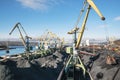 Mountains of coal on the territory of the Murmansk Commercial Sea Port. The unloading of wagons with coal and the loading of this Royalty Free Stock Photo