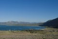 Mountains road trip. Mono Lake and mountains in the distance, blue sky and asphalt road in yearly morning Royalty Free Stock Photo