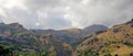 Mountains on the east coast of Sicily, clouds above the mountains, the slopes of the mountains descending towards the sea coast Royalty Free Stock Photo