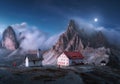 Mountains in fog with beautiful house and chapel at night