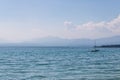 Mountains in the fog with the boats on Garda lake during in Bardolino, Italy - Image Royalty Free Stock Photo