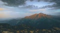 Mountains green lake with reflections and rocky shore in autumn time. Wild nature and rural mount valley. Fall grey weather rainy