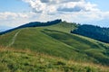 Mountains hills landscape during a sunny day with blue sky clouds. Dark autumn trees. Forest in summer. Hiking in wild mountains.