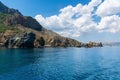 The mountains of the Karadag reserve, going into the sea, in the background a fragment of the city, Crimea