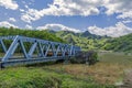 Mountains landscape with passenger train crossing a bridge