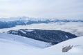 Mountains of main Caucasian Ridge covered with snow and forest and wooden fence