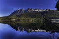 Mountains in morning light reflected in calm lake waters