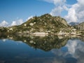 Mountains reflect on small alpine lake on the Bergamo Alps