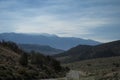 Mountains road trip. Mountain in the distance, blue sky and asphalt road in yearly morning Royalty Free Stock Photo