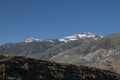 Mountains road trip. Snow mountains in the distance, blue sky yearly morning Royalty Free Stock Photo