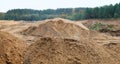 Mountains of sand in the forest at the construction site of new Royalty Free Stock Photo