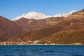 Mountains by the sea, winter Mediterranean landscape on sunny day. Montenegro, Bay of Kotor. View of snow-capped mountain of Orjen