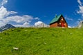 Mountains and small wooden house on green field, Zabljak, Montenegro Royalty Free Stock Photo