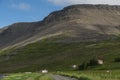 Mountains and some building on a Hill on iceland