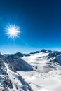 Mountains, sun with flare. There is a lot of snow in the mountains Royalty Free Stock Photo