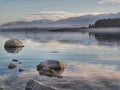 Mountains and trees reflecting in the waters of Lake Pukaki at Mackenzie Basin of the South Island of New Zealand Royalty Free Stock Photo