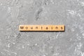 Mountains word written on wood block. mountains text on cement table for your desing, concept Royalty Free Stock Photo