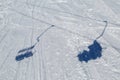 On the mountainside the shadows of the skiers going up on ski-lift are displayed Royalty Free Stock Photo