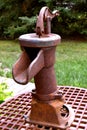 Old rusty hand water pump attached to a metal grate Royalty Free Stock Photo