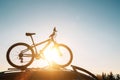 Mounted mountain bicycle silhouette on the car roof with evening sun light rays background. Safe sport items transportation using Royalty Free Stock Photo