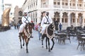 Mounted police patrol the main thoroughfare of Souq Waqif in Qatar with in background the famous `Le Pouce`, a sculpture by acclai