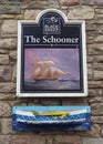 The mounted wooden Pub Sign and Wooden Boat Flower Planter of the The Schooner Pub in Seahouses