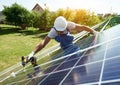 Mounter installing solar panels for renewable energy on house`s roof.